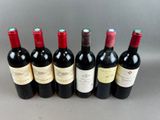 six bottles of wine lined up in a row on a table