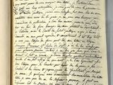 un livre ouvert avec une écriture dessus, posé sur une table