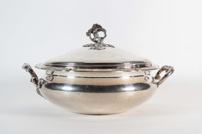 an antique silverplated bowl with a lid and handles on a white background
