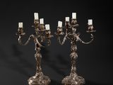 a pair of silver plated candelabs with candles