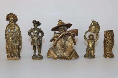 cinq figurines posées sur une surface blanche