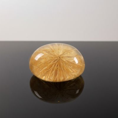 an image of a yellow glass object on a black surface