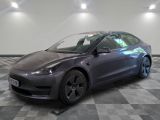 the tesla model 3 is parked on a checkered tile floor