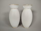 pair of white vases with gold rims on a gray background