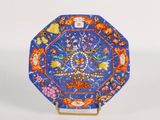 a blue plate with a design of flowers and birds on it