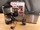 une cafetière, un grille-pain, un grille-pain et un autre grille-pain posés sur une table