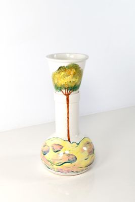 un vase blanc orné d'un arbre, posé sur une table