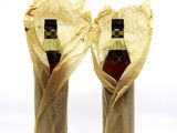 two bottles of wine wrapped in a brown paper bag