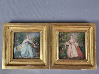 Deux tableaux représentant des femmes en robe sont accrochés au mur.