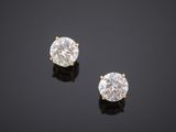 a pair of diamond earrings on a black surface