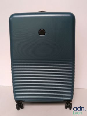 the blue suitcase is sitting on wheels on a white surface