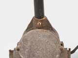 a small metal object with a black handle on a white surface
