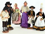 five figurines of people dressed in different costumes