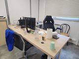 a desk with two computers and a chair in a room