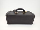 the brown leather suitcase is sitting on a white surface