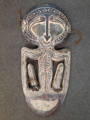 une image d'un masque en bois accroché au mur