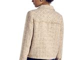 a woman in jeans and a jacket stands against a white background