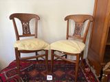 two chairs that are sitting on a rug in a room