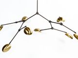 un gros plan d'un lustre en métal orné de feuilles dorées