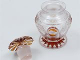 a small glass vase and a small glass object on a white surface