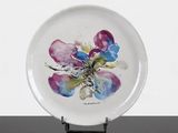 a white plate with a painting of flowers on it