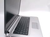 a silver laptop with a black keyboard on a white surface