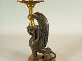 a bronze statue of a winged bird on a pedestal