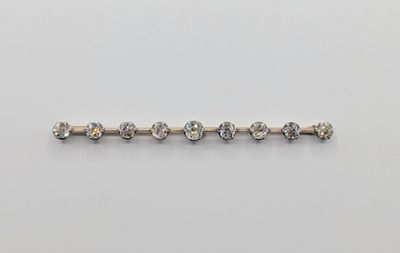 une broche en forme de barre de diamants sur fond blanc