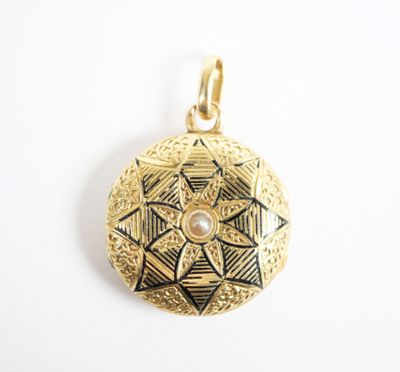 a close up of a gold locke with a pearl in the center