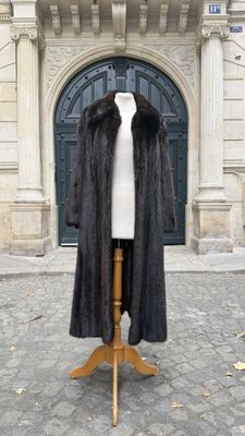 un manteau de fourrure posé sur un mannequin devant un immeuble