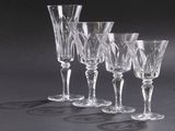 four empty wine glasses are lined up on a black surface