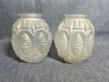 une paire de vases en verre blanc posés sur un tissu gris