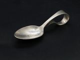 silver spoon on a black surface with a black background