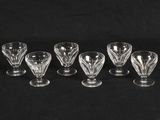 a set of six glass goblets on a black background