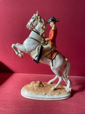 figurine représentant un homme à cheval sur un fond rouge
