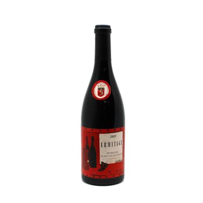 a bottle of red wine sitting on top of a white table