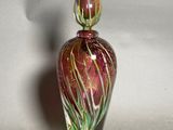 a glass vase with a red and green design on it