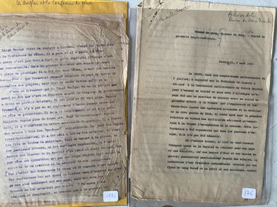 two pages of old paper with writing on them sitting on a table