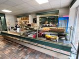 une photo d'une boulangerie dont le comptoir est rempli de pâtisseries