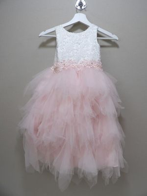 pink and white dress hanging on a hanger against a wall