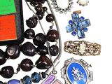 a cell phone that is surrounded by a bunch of necklaces