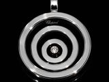 a black and white photo of a pendant with a diamond in it
