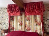 a bed with a red comforter in a bedroom