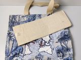 une photo d'un sac fourre-tout bleu et blanc orné d'une carte du monde