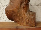 a wooden bust of a man on a wooden shelf