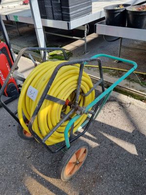 un chariot muni d'un tuyau, garé sur le bord de la route