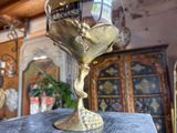 a gold wine glass sitting on top of a wooden table