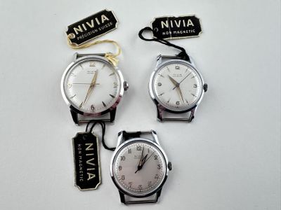 trois montres sont assises l'une à côté de l'autre sur une surface blanche