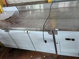 stainless steel counter top with two doors and a drawer underneath it