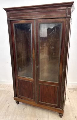 une photo d'une armoire en bois avec des portes vitrées dans une pièce